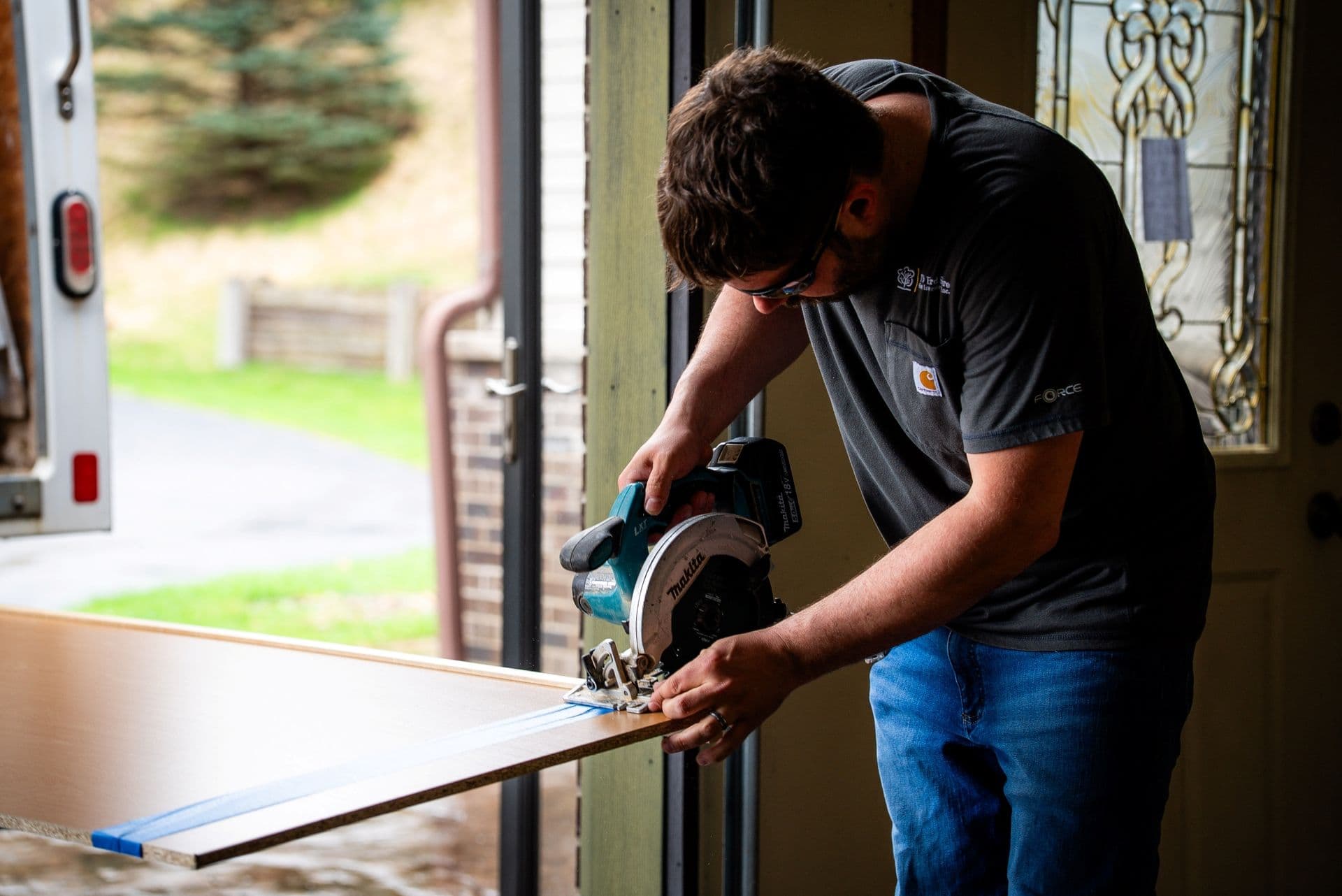 A worker cuts material with a circular saw.
