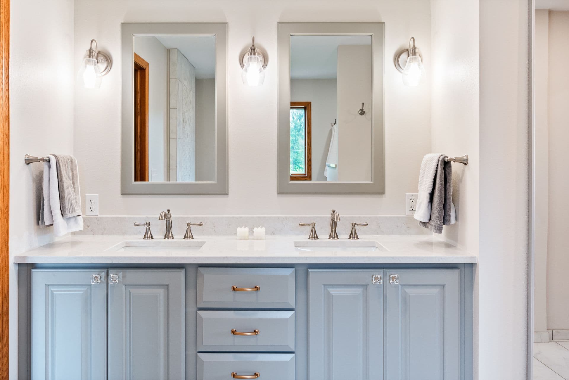 A double vanity with white countertop and light blue cabinets.