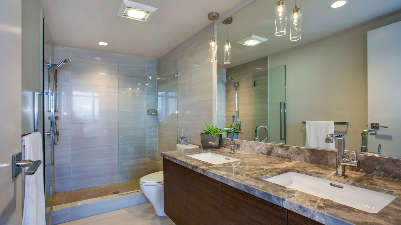 A bathroom with a walk-in shower an a two-sink vanity